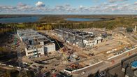 ilmakuvassa työmaa, kaksi iso rakennuskompleksia, sähkömuuntajakenttä, kymmeniä nostureita, paljon rakennustarvikkeita ja työmaa-ajoneuvoja ympäriinsä.