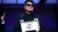 Jafar Panahi står på scen med Gyllene palmen-priset i händerna.