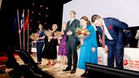 Demareiden upoluejohto juhlii lavalla kukkakimppuja heiluttaen.