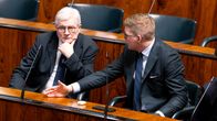 Johannes Koskinen ja Antti Lindtman keskustelevat eduskunna istuntosalissa.