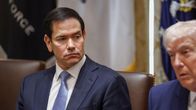 Marco Rubio istuu neuvottelupöydässä, katsoo sivulleen. 