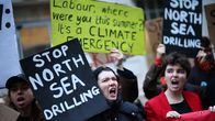 Ihmisiä seisoo yhdessä pitäen kylttejä, joissa lukee ”STOP NORTH SEA DRILLING” ja ”It’s a CLIMATE EMERGENCY”.