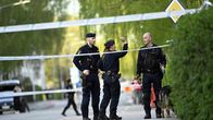 Poliisikoira ja poliisit työskentelevät poliisinauhoilla eristetyllä alueella.