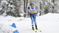 Mies hiihtää Suomen maajoukkueen kisa-asussa.