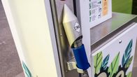 Sininen biokaasun tankkausletku tankkausaseman telakassa, jossa tarra tekstillä "CNG".