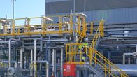 Kuvaa Haminan LNG-terminaalin porttien sisältä. Nainen laskeutuu keltaisia portaita alas.