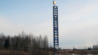 Korkea mainostolppa keväisen pellon keskellä. Tolpassa lukee Sunny Car Center.