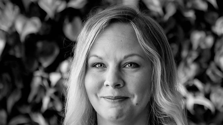 Mustavalkoinen kuva naisesta. Kuvan päällä teksti: "Työskentelemme rennossa ympärisössä, mutta intohimolla. Ylellä pyrimme aina laadukkaaseen lopputulokseen, ja koen saavani tehdä merkityksellistä työtä." Tiina, ohjelmistokehittäjä.