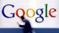 Mies kävelee vauhdilla Googlen logon ohi.