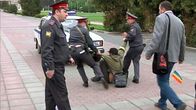 Poliisi raahaa aktivistia poliisiautoon