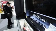 Asiakas katselee Sonyn Playstation-konsolia elektroniikkakaupassa Tokiossa.