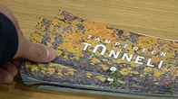 Mies ottaa Tampereen tunneli -esitettä pöydältä 