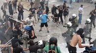 Mielenosoittajat ja mellakkapoliisi ottavat yhteen parlamenttitalon edustalla.