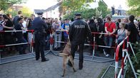Ihmisiä poliisin suoja-aitojen takana.