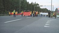 Mielenosoittajia tiellä.