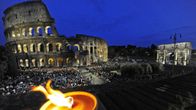 Colosseum iltavalaistuksessa ja paljon ihmisiä sen ympärillä.