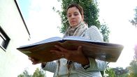 Kirjailija Titta Kallio-Seppä Iin arkeologisista kaivauksista kertovan kirjan kanssa.