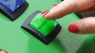 Naisen käsi painaa peliautomaatin käynnistysnappia.