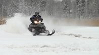 Moottorikelkkaa syöksyy jäätä pitkin kohti kameraa
