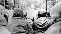 Suomalaisia lumipukuisia sotilaita konekivääriasemassa rintamalla, Laatokan Karjalassa etulinjassa.