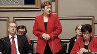 Ympäristöministeri Paula Lehtomäk vastaa eduskunnan kyselytunnilla esitettyyn kysymykseen. Muut ministerit istuvat ja Lehtomäki seisoo.