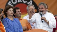 Kuvassa vasemmalla Brasilian entinen presidentti Lula da Silva ja nykyinen presidentti Dilma Roussef. He ovat lavalla. Lula puhuu. 