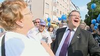 Nauravia ihmisiä tapahtumassa kadulla.