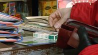 Nainen ostaa tupakkaa kioskilta