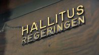 Hallituksen kyltti eduskunnan sisäpuolella.