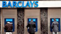 Miehiä nostamassa rahaa Barclays-pankin automaateilta.