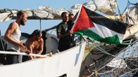 Miehistön jäsen heiluttaa Palestiinan lippua laivan kannella.