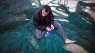 Palestiinalainen kalastaja korjaa verkkoja Gazan kaupungissa