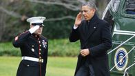 Obama astuu ulos helikopterista ja tervehtii sotilasta.