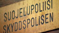 Kuva kyltistä Suojelupoliisin ovessa Helsingin Kruununhaassa.