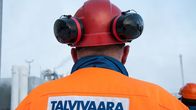 Talvivaaran työntekijä katselee tehtaan piippuja.