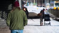 Tuntematon mies kuvattuna selkäpuolelta kävelee eteenpäin kädet taskussa. Taustalla ihmisiä.