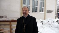 Kirkkoherra Elias Huurinainen seisoo Iisalmen Evakkokeskuksen edessä.
