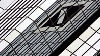 Deutsche Bankin logo vääristyy pilvenpiirtäjän hopeisia ikkunoita vasten.