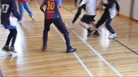 Kids playing football in the gym.