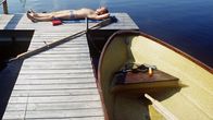Mies ottaa aurinkoa laiturilla.