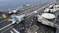 Lentotukialus USS George Washingtonin kannella helikoptereita ja hävittäjiä.