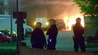 Poliisit katselevat palavaa autoa.