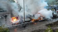 Palomiehet sammuttavat palavia autoja Husbyssä Tukholman esikaupunkialueella.