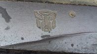 Kuva raitiovaunun kiskoihin kaiverretusta transformers -logosta