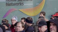 Talvivaatteisiin pukeutuneita ihmisiä Nokia Siemens Networks -tunnuksen edessä.