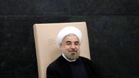 Iranin presidentti Hassan Rouhani myhäilee vaaleanruskealla tuolilla.