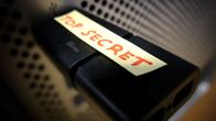 Kuva mustasta muistitikusta, jonka päällä on teksti TOP SECRET.