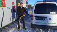 Mies tankkaa kaasuautoa