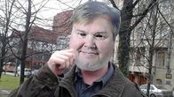 Anonyymi kiakkovieras poseeraa Timo Jutila -maski päässä Hämeenpuistossa.