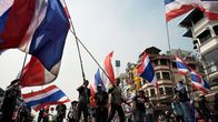 Mielenosoittajat heiluttavat Thaimaan lippuja.